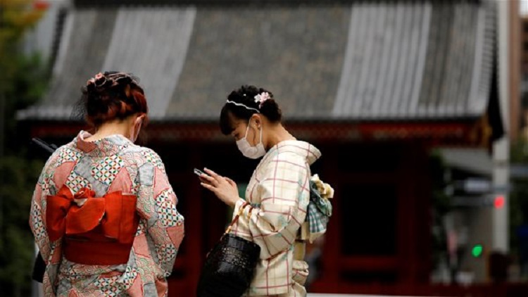 Du khách đến thăm một ngôi đền ở Tokyo. Nhật Bản tạm dừng kế hoạch kích cầu du lịch “Go To Travel” trên toàn quốc trong hai tuần bận rộn nhất trong năm của ngành du lịch. Ảnh: Reuters